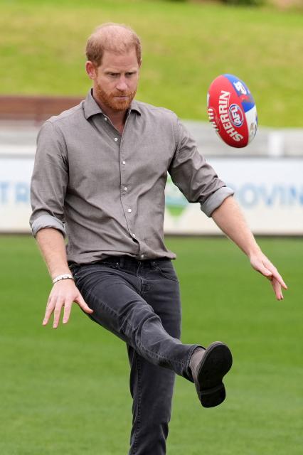 Britain's Prince Harry, Duke of Sussex (C), kicks a ball during a Western Bulldogs Australian rules football session during a visit to a Movember event at Whitten Oval in Melbourne on April 15, 2026. (Photo by Jonathan Brady / POOL / AFP)