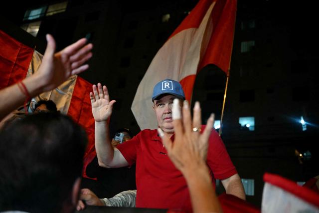 Peru's presidential candidate for the Renovacion Popular party, Rafael Lopez Aliaga, waves to demonstrators during a protest over alleged fraud following the results of the presidential election in front of the National Jury of Elections (JNE) headquarters in Lima on April 14, 2026. Ultra-conservative candidate Rafael Lopez Aliaga, who is vying for a spot in the runoff of Peru’s presidential election, called on election authorities on April 14 to declare the election “null and void” due to unproven irregularities in the process. (Photo by ERNESTO BENAVIDES / AFP)