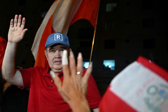 Peru's presidential candidate for the Renovacion Popular party, Rafael Lopez Aliaga, waves to demonstrators during a protest over alleged fraud following the results of the presidential election in front of the National Jury of Elections (JNE) headquarters in Lima on April 14, 2026. Ultra-conservative candidate Rafael Lopez Aliaga, who is vying for a spot in the runoff of Peru’s presidential election, called on election authorities on April 14 to declare the election “null and void” due to unproven irregularities in the process. (Photo by ERNESTO BENAVIDES / AFP)