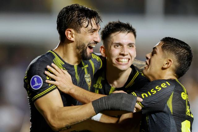 Recoleta's forward #09 Richard Ortiz (L) celebrates with forwards #24 Thiago Vidal and #19 Hector Lopez after scoring the team's first goal during the Copa Sudamericana group stage football match between Brazil's Santos and Paraguay's Deportivo Recoleta at the Urbano Caldeira stadium in Santos, state of Sao Paulo, Brazil, on April 14, 2026. (Photo by Miguel SCHINCARIOL / AFP)