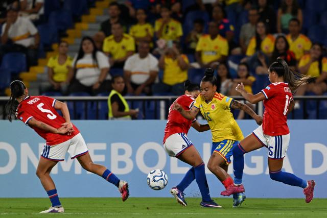 Colombia's forward #15 Wendy Bonilla attempts to dribble past Chile's defender #02 Michelle Olivares and Chile's midfielder #15 Anais Cifuentes during the CONMEBOL Nations League Women football match between Colombia and Chile, at the Olimpico Pascual Guerrero stadium in Cali, Valle del Cauca, Colombia, on April 14, 2026. (Photo by JOAQUIN SARMIENTO / AFP)