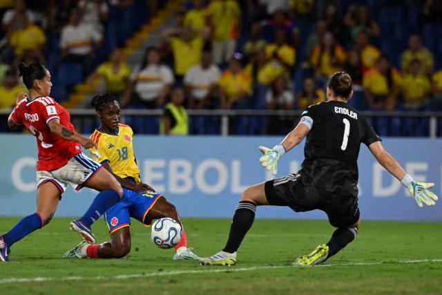 Colombia's forward #18 Linda Caicedo fights for the ball with Chile's defender #02 Michelle Olivares and Chile's goalkeeper #01 Christiane Endler during the CONMEBOL Nations League Women football match between Colombia and Chile, at the Olimpico Pascual Guerrero stadium in Cali, Valle del Cauca, Colombia, on April 14, 2026. (Photo by JOAQUIN SARMIENTO / AFP)