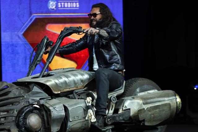 US actor Jason Momoa rides a bike on stage as he promotes the upcoming film “Supergirl” during Warner Bros presentation at CinemaCon at The Colosseum at Caesars Palace on April 14, 2026 in Las Vegas, Nevada. (Photo by VALERIE MACON / AFP)