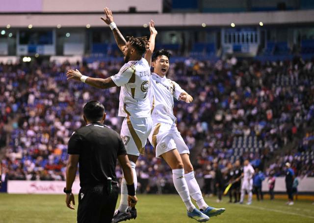 Los Angeles FC's Gabonese forward #99 Denis Bouanga and Los Angeles FC's South Korean forward #07 Son Heung-Min celebrate after the CONCACAF Champions Cup quarterfinal football match between Mexico's Cruz Azul and US' Los AngelesFC (LAFC) at Cuauhtemoc stadium in Puebla, Mexico on April 14, 2026. (Photo by Yuri CORTEZ / AFP)