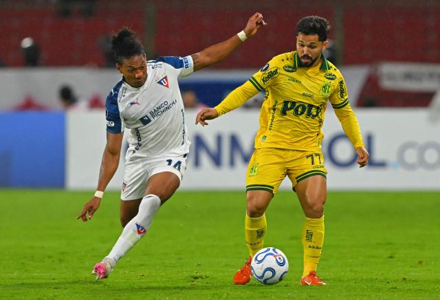 Liga de Quito's defender #14 Jose Quintero and Mirassol's forward #77 Alesson fight for the ball during the Copa Libertadores group stage football match between Ecuador's Liga de Quito and Brazil's Mirassol at the Rodrigo Paz Delgado stadium in Quito on April 14, 2026. (Photo by Rodrigo BUENDIA / AFP)