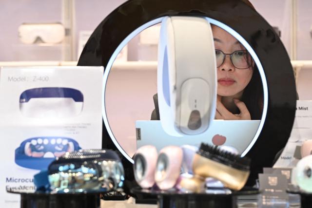 A vendor is seen at her booth at the Hong Kong Electronics Fair 2026 at the Convention and Exhibition Centre in Hong Kong on April 15, 2026. (Photo by Peter PARKS / AFP)