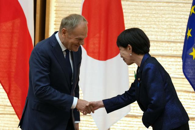 Poland's Prime Minister Donald Tusk (L) shakes hands with Japan's Prime Minister Sanae Takaichi after a news conference at the prime minister's office in Tokyo on April 15, 2026. (Photo by Hiro Komae / POOL / AFP)