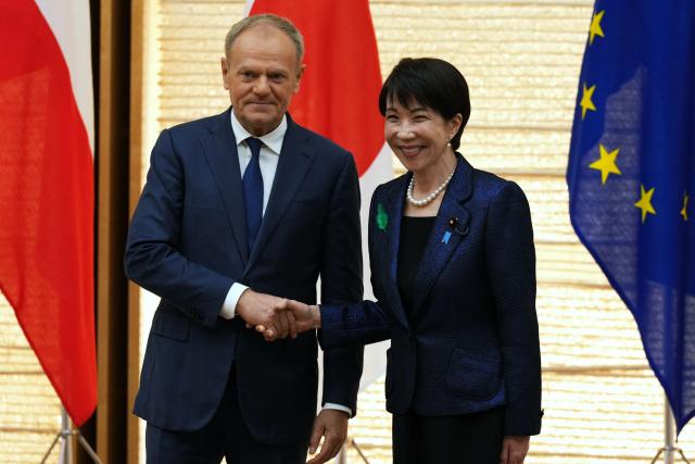 Poland's Prime Minister Donald Tusk (L) shakes hands with Japan's Prime Minister Sanae Takaichi after a news conference at the prime minister's office in Tokyo on April 15, 2026. (Photo by Hiro Komae / POOL / AFP)
