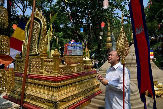 Cambodia's Deputy Prime Minister Hun Many prays next to sand stupas during celebrations for the Khmer New Year, known as Nokor Sankranta, in Phnom Penh on April 15, 2026. (Photo by TANG CHHIN Sothy / AFP)