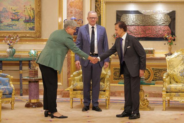 Brunei's Sultan Hassanal Bolkiah (R) shakes hands with Australia's Foreign Minister Penny Wong (L) as Australia's Prime Minister Anthony Albanese (C) looks on prior to a meeting at Istana Nurul Iman in Bandar Seri Begawan on April 15, 2026. Albanese is travelling to Brunei and Malaysia to discuss energy and food security, his office said on April 12, continuing regional efforts to shore up fuel supplies for a nation reliant on imports. (Photo by Muhammad Rudean / AFP)