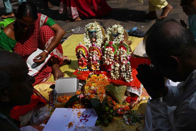Devotees offer prayers in front of Hindu deities to celebrate Bengali new year, at Kalighat temple in Kolkata on April 15, 2026. (Photo by Dibyangshu SARKAR / AFP)