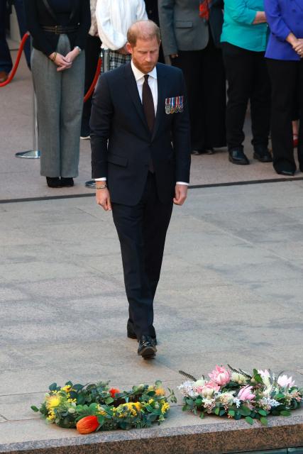 Britain's Prince Harry (C), the Duke of Sussex, reacts after laying a wreath as he takes part in the Last Post ceremony during a visit to the Australian War Memorial in Canberra on April 15, 2026. (Photo by DAVID GRAY / AFP)