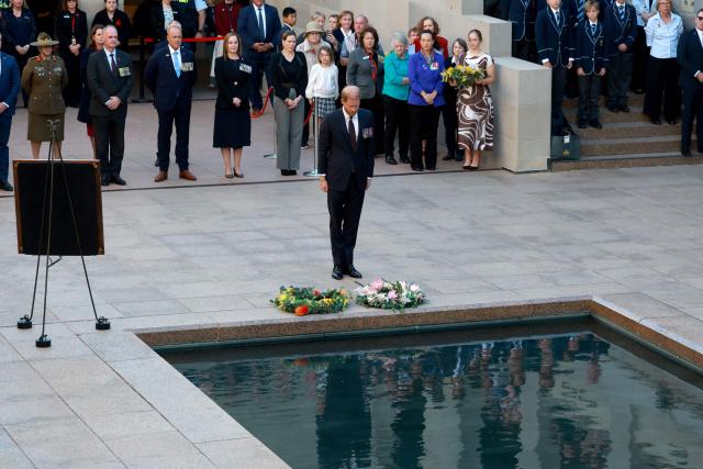 Britain's Prince Harry (C), the Duke of Sussex, reacts after laying a wreath as he takes part in the Last Post ceremony during a visit to the Australian War Memorial in Canberra on April 15, 2026. (Photo by DAVID GRAY / AFP)