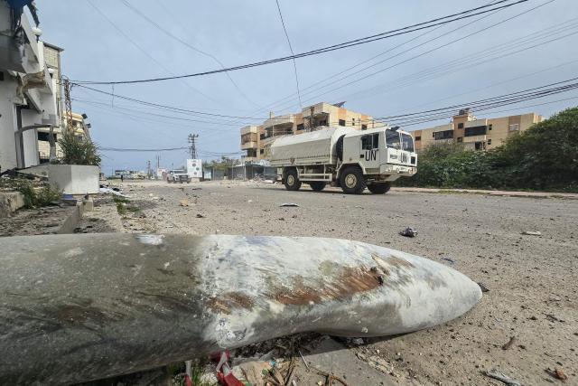 United Nations peacekeepers with the UN Interim Force in Lebanon (UNIFIL) drive past the remains of ordnance in the aftermath of an Israeli airstrike that targeted a building in the southern Lebanese village of Abbasiyeh, on the outskirts of Tyre, on April 15, 2026. The US president said on April 14 that US-Iran peace talks could resume this week, while Israel and Lebanon agreed to launch direct negotiations, signaling movement on two key fronts in efforts to ease the Middle East conflict. (Photo by Kawnat HAJU / AFP)