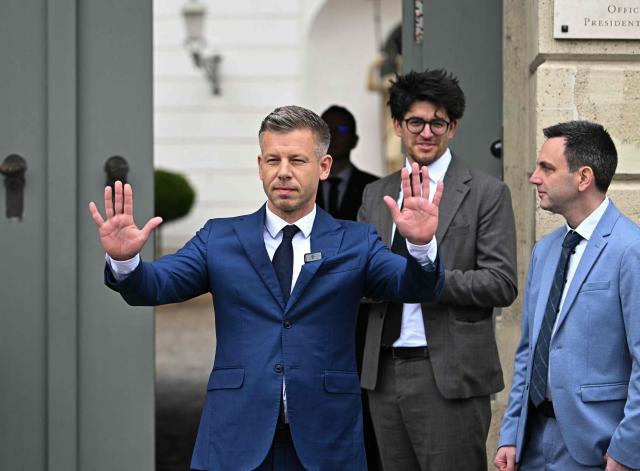 Hungary's prime minister-elect Peter Magyar cheers as he arrives at the entrance of the Presidential Sandor Palace in Budapest on April 15, 2026 before meeting with Hungary's President and other parliamentary parties, two three days after general elections in Hungary. (Photo by Attila KISBENEDEK / AFP)