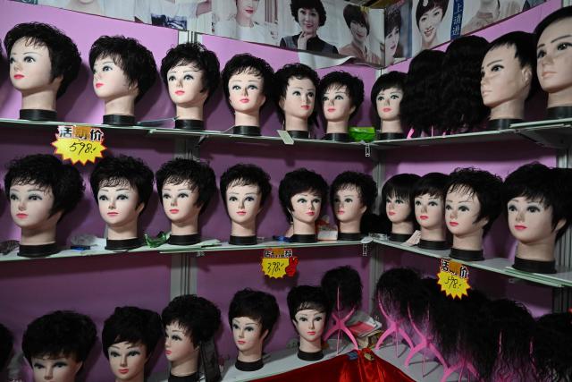 Wigs are displayed for sale at a shop in Beijing on April 15, 2026. (Photo by Pedro PARDO / AFP)