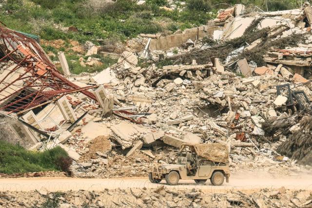 A photograph taken from the Israeli side of the border with Lebanon shows Israeli soldiers driving along a road running beside destroyed buildings in southern Lebanon on April 15, 2026. Lebanon was drawn into the Middle East war in early March when the Tehran-backed Hezbollah launched rockets towards Israel to avenge a US-Israeli attack that killed Iran's supreme leader. Israel has responded with massive strikes across Lebanon and a ground offensive. (Photo by Jack GUEZ / AFP) / 