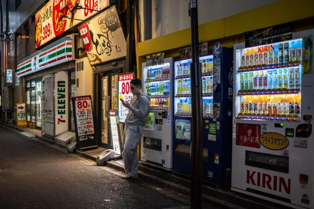 A man looks at his phone in Tokyo's Akihabara neighbourhood on April 15, 2026. (Photo by Philip FONG / AFP)