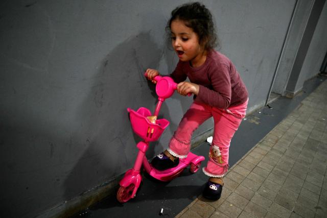 A displaced gril plays on her scooter at a corridor in a school transformed into a displaced reception center in the area of Dekwaneh, east of Beirut on April 15, 2026. United Nations refugee chief Barham Salih on April 15 called on the international community to provide urgent support to Lebanon, with a fifth of the country's population displaced by the Israel-Hezbollah war. (Photo by Joseph EID / AFP)