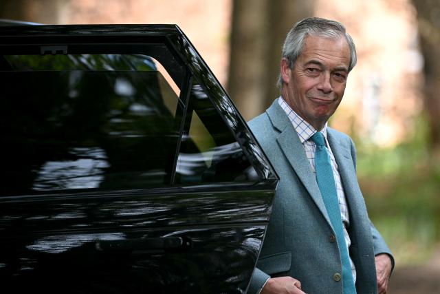 Reform UK party leader Nigel Farage arrives outside the entrance to Crowborough military barracks which houses illegal migrants, during his walkabout to campaign in the town of Crowborough, south-east England on April 15, 2026, ahead of local elections on May 7. (Photo by JUSTIN TALLIS / AFP)