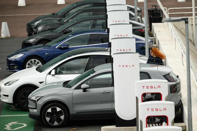 People charge their electric cars at a Tesla electric charging station in Saint-Herblain, western France, on April 15, 2026, as US-Israel war on Iran, launched on February 28, has roiled global energy and equities markets, sending oil prices skyrocketing after Tehran virtually closed the key Strait of Hormuz. (Photo by Loic VENANCE / AFP)