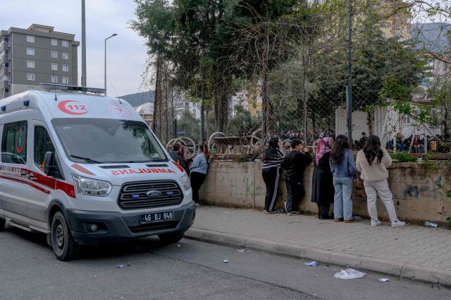 Families stay next to a ambulance in front a school where a 13 year-old teenager opened fire in Kahramanmaras, on April 15, 2026. A 13-year-old opened fire at a Turkish school on April 15, 2026, killing nine people and wounding 13, with students jumping from windows to escape the second school shooting in the country in as many days, officials said. (Photo by Orhan ERKILIC / AFP)