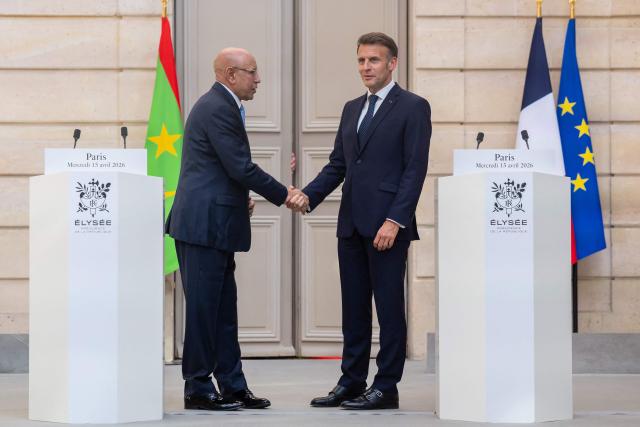 France's President Emmanuel Macron (R) and Mauritania's President Mohamed Ould Cheikh El Ghazouani (L) shake hands wudirng a joint press conference ahead of a state banquet at the Elysee Presidential Palace in Paris on April 15, 2026. (Photo by Christophe PETIT TESSON / POOL / AFP)