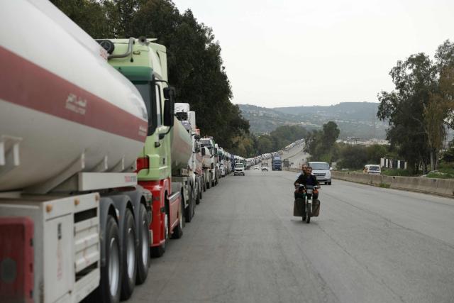 A long convoys of Iraqi diesel-laden tanker trucks line up along the highway Tartus-Baniyas highway as they wait to unload their cargo at the Baniyas port refinery on the Mediterranean Sea, on April 15, 2026. Iraq has begun exporting crude using tanker trucks through Syria, its oil ministry said, as an official said oil revenue last month dropped more than 70 percent compared to February. More than a month into the Middle East war that has wrought havoc on energy markets, Iraq has been particularly impacted as oil exports account for some 90 percent of its budget revenues. Until Iranian attacks and threats all but shut the Strait of Hormuz in revenge for US-Israeli strikes, Iraq exported the majority of its oil through the strategic waterway. (Photo by Bakr ALkasem / AFP)