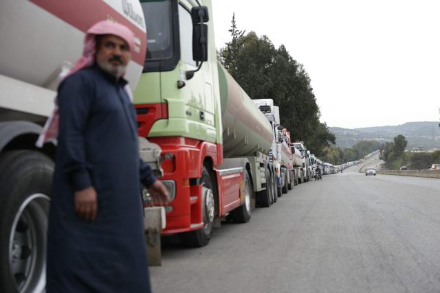 A long convoys of Iraqi diesel-laden tanker trucks line up along the highway Tartus-Baniyas highway as they wait to unload their cargo at the Baniyas port refinery on the Mediterranean Sea, on April 15, 2026. Iraq has begun exporting crude using tanker trucks through Syria, its oil ministry said, as an official said oil revenue last month dropped more than 70 percent compared to February. More than a month into the Middle East war that has wrought havoc on energy markets, Iraq has been particularly impacted as oil exports account for some 90 percent of its budget revenues. Until Iranian attacks and threats all but shut the Strait of Hormuz in revenge for US-Israeli strikes, Iraq exported the majority of its oil through the strategic waterway. (Photo by Bakr ALkasem / AFP)