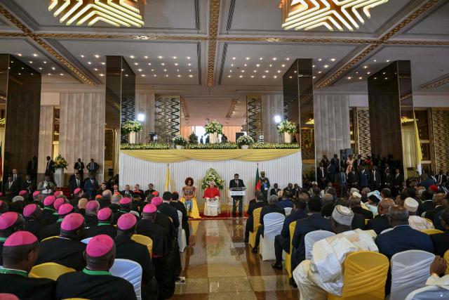 Pope Leo XIV (C) and Cameroon's First Lady Chantal Biya (CL) look on as Cameroon's President Paul Biya (CR) delivers a speech at The Presidential Palace in Yaounde, on the third day of an 11-day apostolic journey to Africa, on April 15, 2026. (Photo by Alberto PIZZOLI / AFP)
