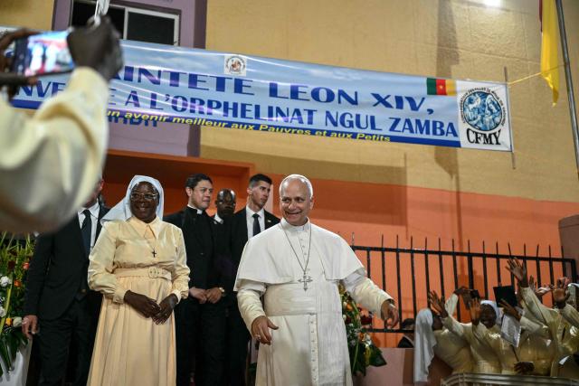 Pope Leo XIV (C) reacts as he leaves after his visit to the Ngul Zamba (Power of God) orphanage in Yaounde, on the third day of an 11-day apostolic journey to Africa, on April 15, 2026. (Photo by Alberto PIZZOLI / POOL / AFP)