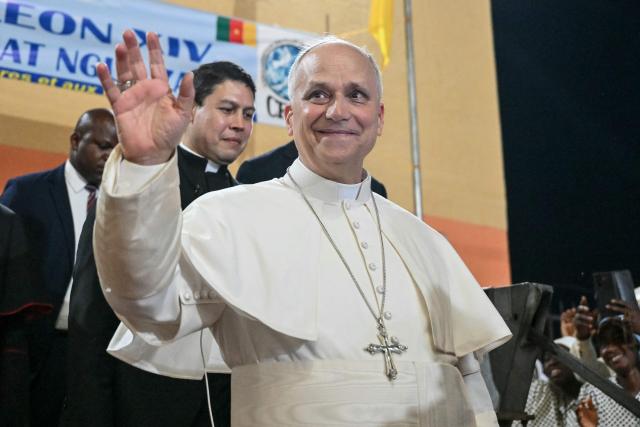 Pope Leo XIV waves to supporters as he leaves after his visit to the Ngul Zamba (Power of God) orphanage in Yaounde, on the third day of an 11-day apostolic journey to Africa, on April 15, 2026. (Photo by Alberto PIZZOLI / POOL / AFP)