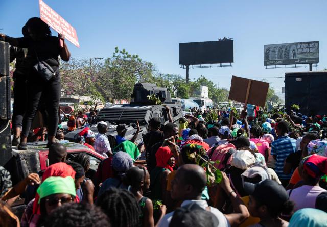An armored police vehicle monitors the area as protestors rally against rising fuel prices in Port-au-Prince, Haiti, on April 15, 2026. Workers say that fuel prices should not exceed their minimum wage. Crude prices climbed Wednesday while stocks diverged as investors digested mixed signals about talks to end the war in the Middle East and get oil and gas flowing through the Strait of Hormuz once again. (Photo by Clarens SIFFROY / AFP)