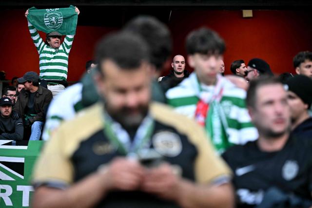 A sporting fan holds a flag aloft before the UEFA Champions League quarter-final, second-leg football match between Arsenal and Sporting Lisbon at the Emirates Stadium in north London on April 15, 2026. (Photo by Ben STANSALL / AFP)