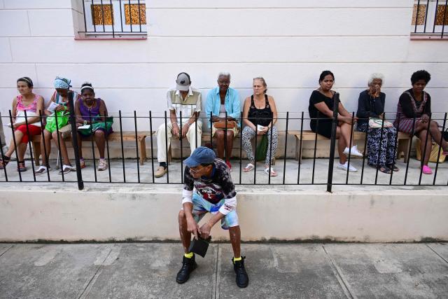 Elderly people line up to receive free medicine as social assistance at the Church of the Holy Cross of Jerusalem in Havana on April 14, 2026. Dozens of people, mainly elderly and low income persons, come to this church to receive free medicines they cannot find in pharmacies or hospitals, reflecting the social role churches are playing in a Cuba in crisis. (Photo by YAMIL LAGE / AFP)