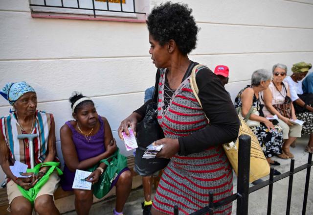 A woman leaves after receiving free medicines as part of a social assistance program at the Church of the Holy Cross of Jerusalem in Havana on April 14, 2026. Dozens of people, mainly elderly and low income persons, come to this church to receive free medicines they cannot find in pharmacies or hospitals, reflecting the social role churches are playing in a Cuba in crisis. (Photo by YAMIL LAGE / AFP)