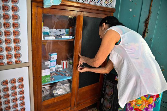 An assistant selects medicines to distribute to elderly worshippers at the Nazareth Baptist Church in the neighborhood of La Vibora, in Havana, on April 14, 2026. Dozens of people, mainly elderly and low income persons, come to this church to receive free medicines they cannot find in pharmacies or hospitals, reflecting the social role churches are playing in a Cuba in crisis. (Photo by ADALBERTO ROQUE / AFP)