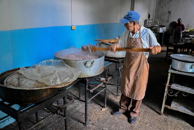 A cook prepares food for elderly worshippers at the Nazareth Baptist Church in the neighborhood of La Vibora, in Havana, on April 14, 2026. Dozens of people, mainly elderly and low income persons, come to this church to receive free medicines they cannot find in pharmacies or hospitals, reflecting the social role churches are playing in a Cuba in crisis. (Photo by ADALBERTO ROQUE / AFP)