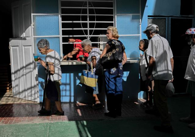 Elderly worshippers receive a free meal at the Nazareth Baptist Church in the neighborhood of La Vibora, in Havana, on April 14, 2026. Dozens of people, mainly elderly and low income persons, come to this church to receive free medicines they cannot find in pharmacies or hospitals, reflecting the social role churches are playing in a Cuba in crisis. (Photo by ADALBERTO ROQUE / AFP)