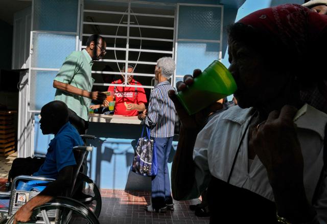 Elderly worshippers receive a free meal at the Nazareth Baptist Church in the neighborhood of La Vibora, in Havana, on April 14, 2026. Dozens of people, mainly elderly and low income persons, come to this church to receive free medicines they cannot find in pharmacies or hospitals, reflecting the social role churches are playing in a Cuba in crisis. (Photo by ADALBERTO ROQUE / AFP)