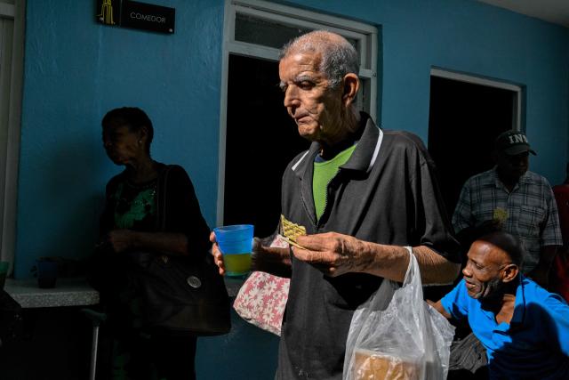 An elderly worshipper carries a bag after receiving a free meal at the Nazareth Baptist Church in the neighborhood of La Vibora, in Havana, on April 14, 2026. Dozens of people, mainly elderly and low income persons, come to this church to receive free medicines they cannot find in pharmacies or hospitals, reflecting the social role churches are playing in a Cuba in crisis. (Photo by ADALBERTO ROQUE / AFP)