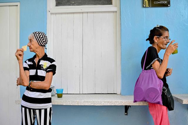 Elderly women eat a free meal at the Nazareth Baptist Church in the neighborhood of La Vibora, in Havana, on April 14, 2026. Dozens of people, mainly elderly and low income persons, come to this church to receive free medicines they cannot find in pharmacies or hospitals, reflecting the social role churches are playing in a Cuba in crisis. (Photo by ADALBERTO ROQUE / AFP)
