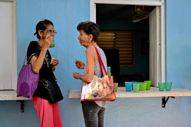 Elderly women eat a free meal at the Nazareth Baptist Church in the neighborhood of La Vibora, in Havana, on April 14, 2026. Dozens of people, mainly elderly and low income persons, come to this church to receive free medicines they cannot find in pharmacies or hospitals, reflecting the social role churches are playing in a Cuba in crisis. (Photo by ADALBERTO ROQUE / AFP)