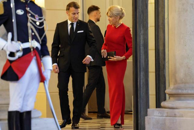 France's President Emmanuel Macron and his wife Brigitte Macron react as they arrive to welcome Mauritania's President Mohamed Ould Ghazouani prior to a state banquet held in his honour at the Elysee Presidential Palace in Paris on April 15, 2026. (Photo by Ludovic MARIN / AFP)
