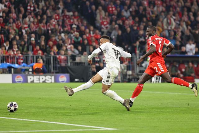 TOPSHOT - Real Madrid's French forward #10 Kylian Mbappe (L) gets past Bayern Munich's French defender #02 Dayot Upamecano to scores the 2-3 goal during the UEFA Champions League quarter-final second leg football match between FC Bayern Munich and Real Madrid in Munich, southern Germany, on April 15, 2026. (Photo by Alexandra BEIER / AFP)
