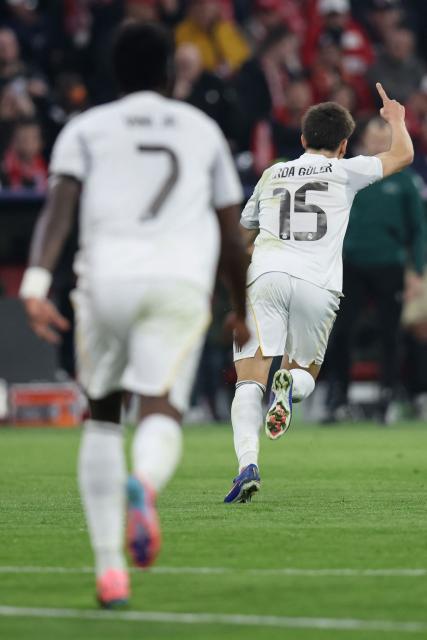 Real Madrid's Turkish midfielder #15 Arda Guler (R) celebrates scoring the 1-2 goal with his teammates during the UEFA Champions League quarter-final second leg football match between FC Bayern Munich and Real Madrid in Munich, southern Germany, on April 15, 2026. (Photo by Alexandra BEIER / AFP)