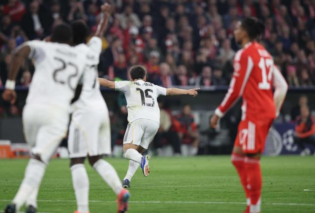 Real Madrid's Turkish midfielder #15 Arda Guler (C) celebrates scoring the 1-2 goal with his teammates during the UEFA Champions League quarter-final second leg football match between FC Bayern Munich and Real Madrid in Munich, southern Germany, on April 15, 2026. (Photo by Alexandra BEIER / AFP)