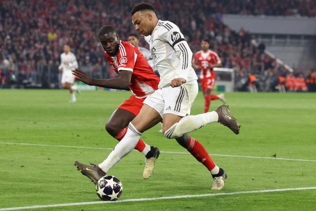 Real Madrid's French forward #10 Kylian Mbappe (R) and Bayern Munich's French defender #02 Dayot Upamecano vie for the ball during the UEFA Champions League quarter-final second leg football match between FC Bayern Munich and Real Madrid in Munich, southern Germany, on April 15, 2026. (Photo by Alexandra BEIER / AFP)