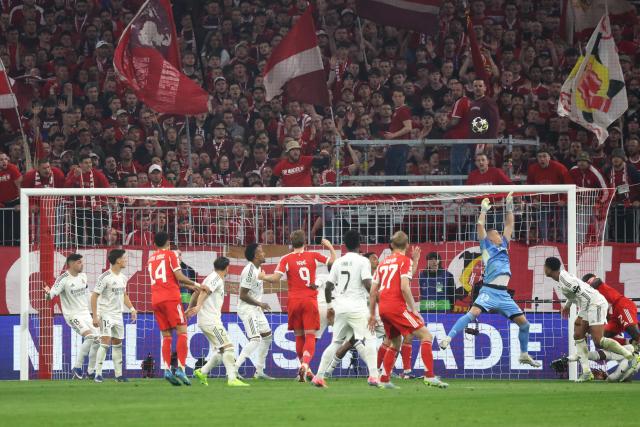 Real Madrid's Ukrainian goalkeeper #13 Andriy Lunin (3rd R) jumps to catch the ball against an attempt to score during the UEFA Champions League quarter-final second leg football match between FC Bayern Munich and Real Madrid in Munich, southern Germany, on April 15, 2026. (Photo by Karl-Josef HILDENBRAND / AFP)