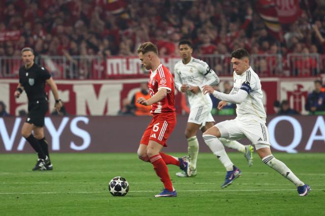 Bayern Munich's German midfielder #06 Joshua Kimmich (L) and Real Madrid's Uruguayan midfielder #08 Federico Valverde (R) vie for the ball during the UEFA Champions League quarter-final second leg football match between FC Bayern Munich and Real Madrid in Munich, southern Germany, on April 15, 2026. (Photo by Karl-Josef HILDENBRAND / AFP)